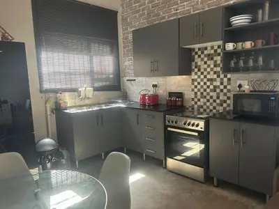 a kitchen with a stove and a table in it at Kumba Mzansi in Musina