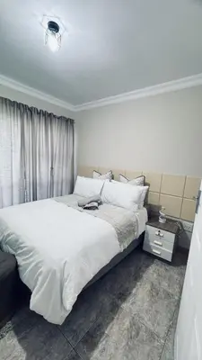 a bedroom with a large bed with white sheets at Casa Tranquila Luxe in Pretoria