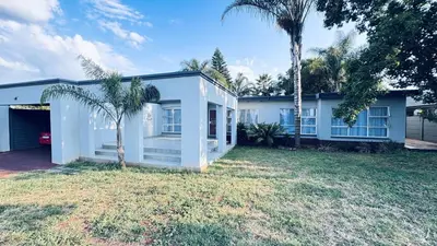 a white house with a palm tree in front of it at Casa Tranquila Luxe in Pretoria