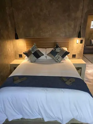 a bedroom with a large bed with pillows at Villa Calao in Marloth Park