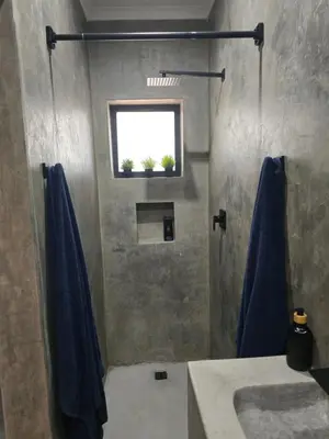 a bathroom with a shower with a sink and a window at Villa Calao in Marloth Park