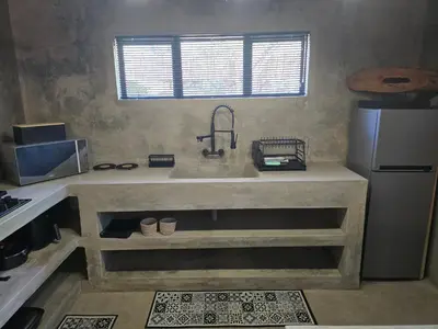 a kitchen with a sink and a refrigerator at Villa Calao in Marloth Park