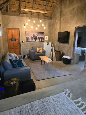 a living room with a couch and a tv at Villa Calao in Marloth Park