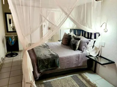 a bedroom with a bed with a canopy at Optibos - 3 Bedroom Holiday Home 6 Sleeper in Marloth Park