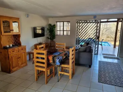 a living room with a table and a couch at Optibos - 3 Bedroom Holiday Home 6 Sleeper in Marloth Park