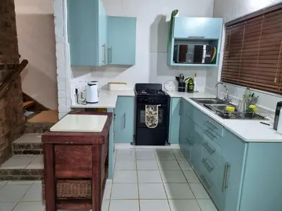 a small kitchen with blue cabinets and a stove at Optibos - 3 Bedroom Holiday Home 6 Sleeper in Marloth Park