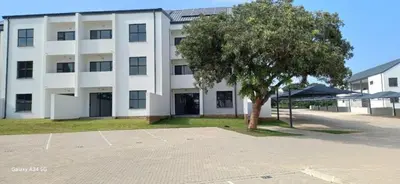 a white building with a tree in front of it at Chillasclub BNB-SAFUBI VIEWS in Nelspruit