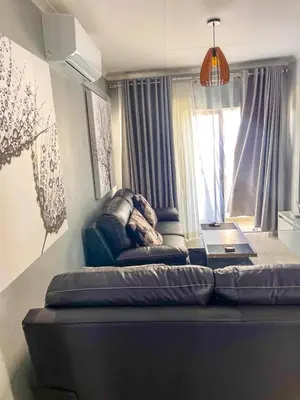 a couch in a living room with a window at Chillasclub BNB-SAFUBI VIEWS in Nelspruit