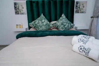 a bed with green and white pillows on it at 22 On End luxurious & modern yet private escape in Centurion