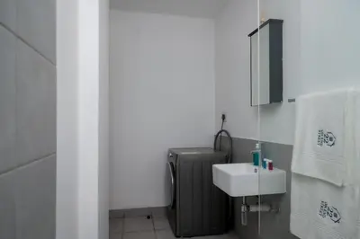 a bathroom with a sink and a suitcase at 22 On End luxurious & modern yet private escape in Centurion
