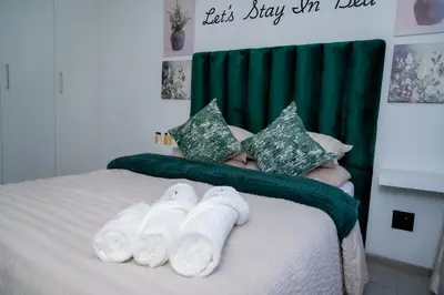 a bed with white towels on top of it at 22 On End luxurious & modern yet private escape in Centurion
