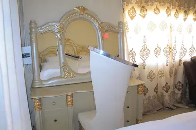 a room with a bed with a mirror and a table at Comfort stay Guesthouse in Mokopane