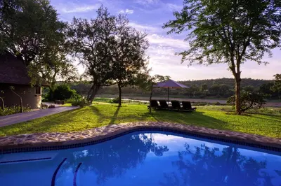 a swimming pool in a yard with a gazebo at Emhosheni River Lodge in Balule Game Reserve