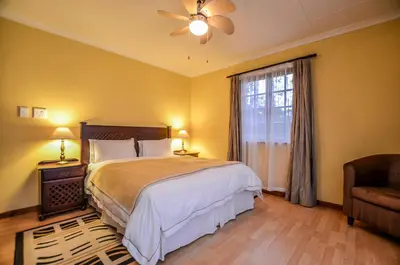 a bedroom with a large bed and a window at White House Lodge in White River