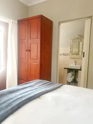a bedroom with a bed and a red cabinet at Gecko Cottages in Hectorspruit