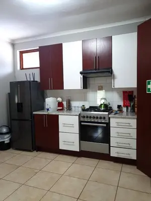 a kitchen with a stove and a refrigerator at Gecko Cottages in Hectorspruit