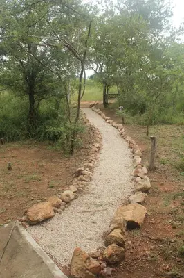 a stone path in the middle of a field at Sweni Lodge 91 Mjejane Kruger Park in Hectorspruit