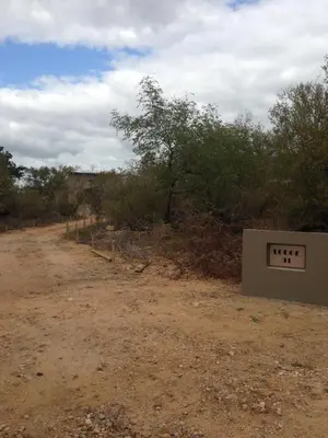 a dirt road with a sign on the side at Sweni Lodge 91 Mjejane Kruger Park in Hectorspruit
