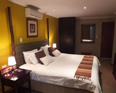 a bedroom with a large white bed in a room at Acacia Guest House in Nelspruit