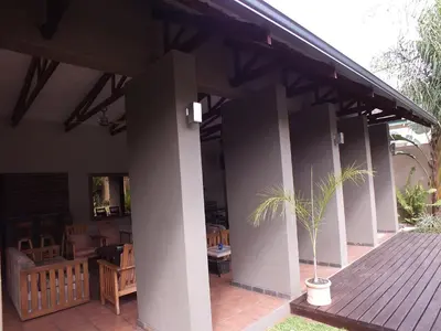 a house with a porch with a potted plant on it at Acacia Guest House in Nelspruit