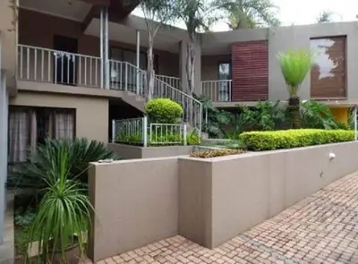 a building with a courtyard with plants in front of it at Acacia Guest House in Nelspruit