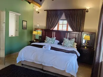 a bedroom with a large bed and a window at Kassaboera Lodge in Hartbeespoort