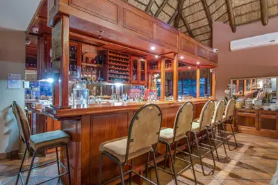 a bar with a row of chairs in a room at Kassaboera Lodge in Hartbeespoort