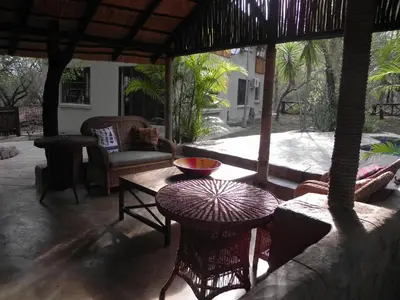 an outdoor patio with a table and a couch at Marloth Kruger Little Manor in Marloth Park