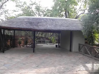 a pavilion with a grass roof on a patio at Marloth Kruger Little Manor in Marloth Park