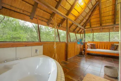 a large bath tub in a room with a couch at Marloth Kruger Little Manor in Marloth Park