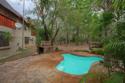 a swimming pool in front of a house at Marloth Kruger Little Manor in Marloth Park