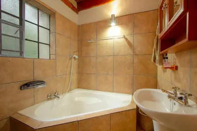a bathroom with a tub and a sink at Marloth Kruger Little Manor in Marloth Park