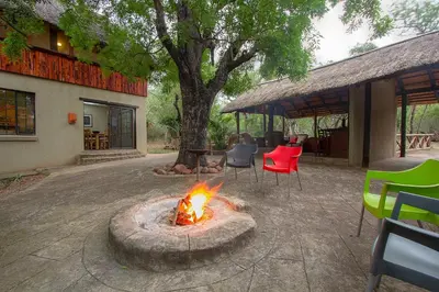 a fire pit in a yard with a table and chairs at Marloth Kruger Little Manor in Marloth Park