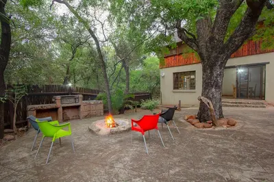 a group of chairs sitting around a fire in a yard at Marloth Kruger Little Manor in Marloth Park
