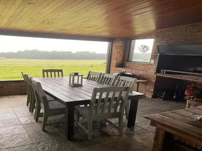 a dining room with a table and chairs and a fireplace at Angel's Rest in Dullstroom
