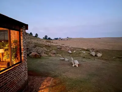 a bench sitting in a field next to a building at Angel's Rest in Dullstroom