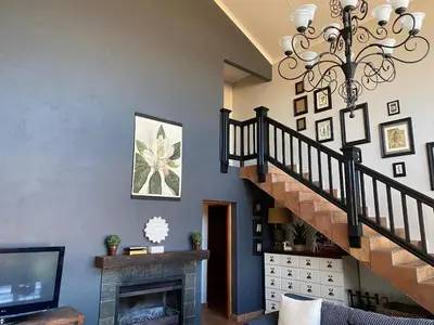 a living room with a staircase and a chandelier at Angel's Rest in Dullstroom