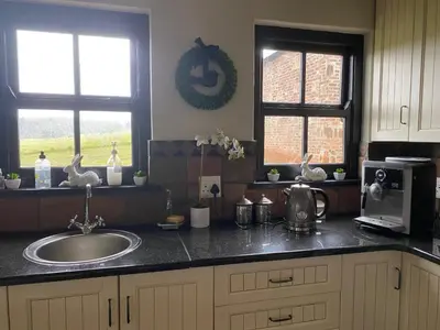 a kitchen counter with a sink and two windows at Angel's Rest in Dullstroom