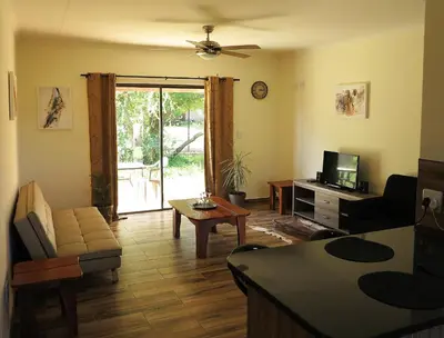 a living room with a couch and a tv at Lodge Huge Dassie in Bela-Bela