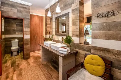 a bathroom with two sinks and a mirror at Bambuu Lakeside Lodge in Hazyview