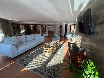 a living room with a couch and a tv at Bambuu Lakeside Lodge in Hazyview