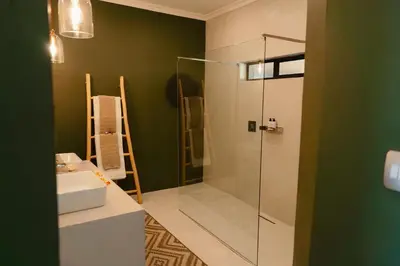 a bathroom with a glass shower and a sink at Bambuu Lakeside Lodge in Hazyview