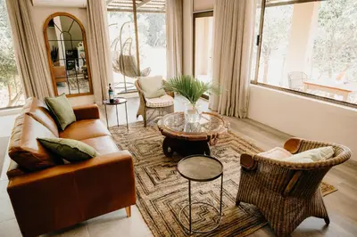 a living room with a couch and chairs and a table at Bambuu Lakeside Lodge in Hazyview