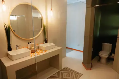 a bathroom with a sink and a mirror and a toilet at Bambuu Lakeside Lodge in Hazyview