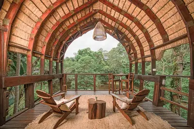 an arched room with chairs and a table on a deck at Serenity Mountain and Forest Lodge in Malelane