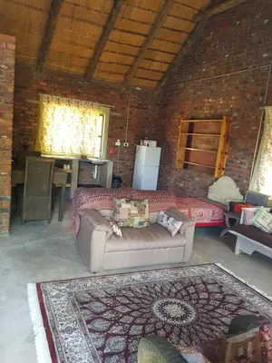 a living room with a couch and a brick wall at Rio Dos Elefantes River Camp in Hoedspruit