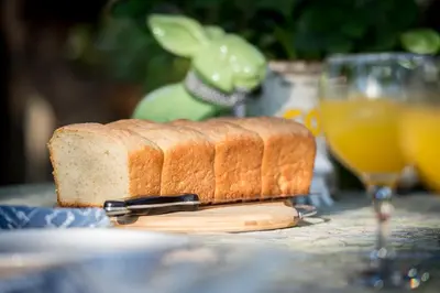 a loaf of bread sitting on a table with a glass of orange juice at Rio Dos Elefantes River Camp in Hoedspruit