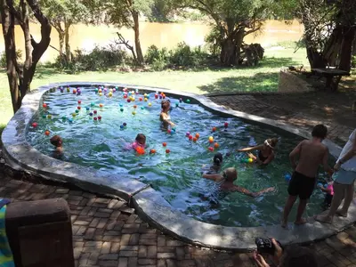 a group of people playing in a swimming pool at Rio Dos Elefantes River Camp in Hoedspruit