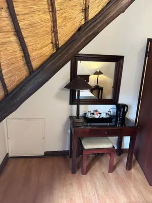 a desk with a mirror and a chair in a attic at Foundry Guest Lodge in Pretoria