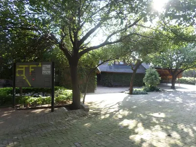 a tree in a park with a sign next to it at Foundry Guest Lodge in Pretoria